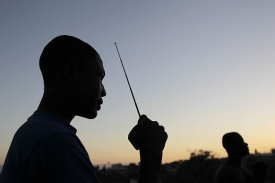 Muž v uprchlickém táboře poblíž Port-au-Prince komunikuje rádiem.